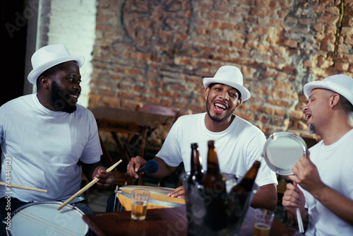 Band, men and play samba music while singing for carnival night, event and live performance with drums. Musicians, artists and beer for fun show in rio de janeiro, happy and celebration for parade