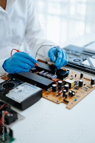 Electronics technician, electronic engineering electronic repair,electronics measuring and testing, repair and maintenance concepts.uses a voltage meter to check and upgrade