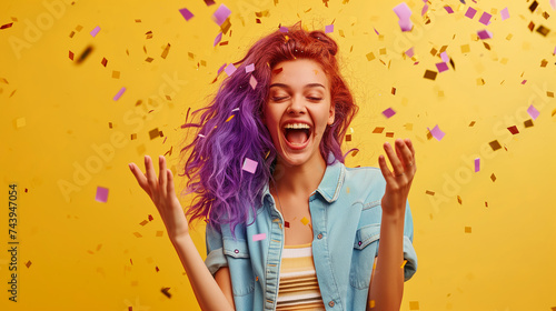 portrait of funny woman smiling, confetti on yellow background. Celebration and party. Having fun.