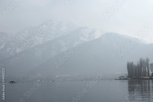 Srinagar, Jammu and Kashmir / India - December 17, 2019 : A view of the Dal lake, and the beautiful mountain range in the background in the city of Srinagar.