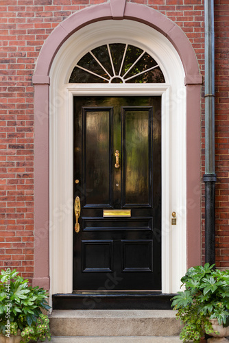 A striking black door, embraced by a flowing arch, exudes sophistication and charm.