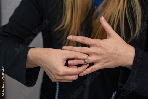 Kobieta zdejmuje z palca obrączkę ślubną, rozstanie 