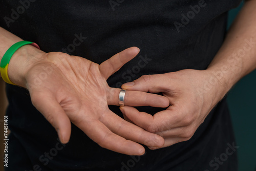 Mężczyzna próbuje zdjąć obrączkę po rozwodzie 