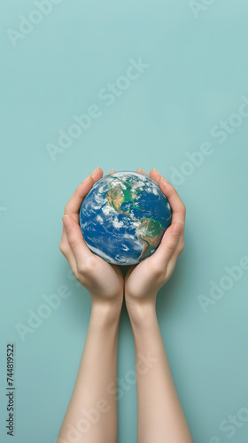 Deux mains tenant une représentation de la terre au format portrait.