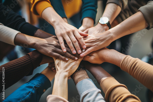 Group of multiethnic people holding hands together. Diversity concept, Team members putting hands together close-up, top view, No visible faces. diverse team putting their hands together.