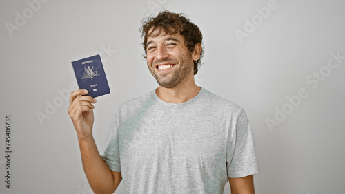 Confident, happy young man joyfully holds his australian passport, smiling against an isolated white background, ready for his next holiday adventure