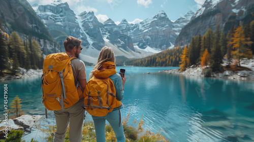 Travelers couple look at the mountain lake. Travel and active life concept with team. Adventure and travel in the mountains at summer