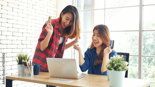 Two friends shopping using credit card online shopping on website laptop e-commerce website with smiling face, happiness. Happy asian women using laptop shopping online buy, payment newnormal concept