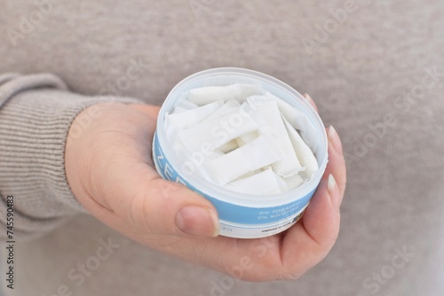 A woman opens a box of nicotine snus.