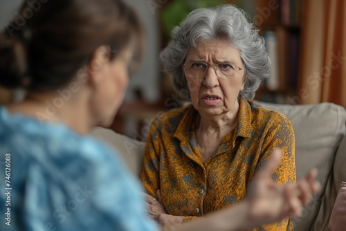 Older woman showing a displeased expression while talking to another adult