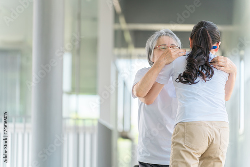 立ち上がり・移動介助する介護士と高齢者女性（日本人） 