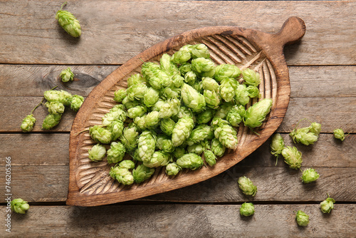 Board with fresh green hops on wooden background