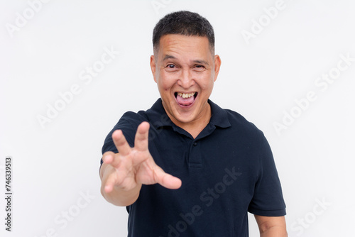 A lusty and pervy middle aged asian man reaching out with his hand, toungue out. Isolated on a white background.