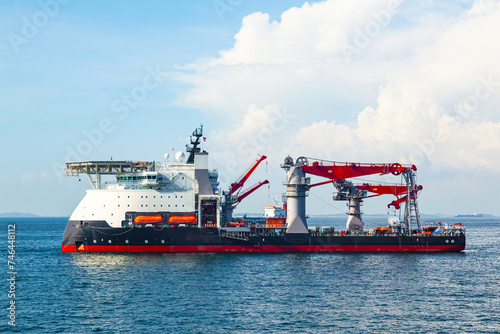 Multi-purpose supply vessel is anchored in a sea bay.