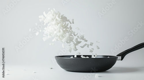 Chopped onion gracefully suspended mid-air, originating from a pan
