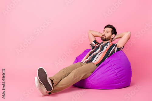 Full length body photo of take nap man chill out sleeping carefree on comfortable beanbag lounge room isolated over pink color background