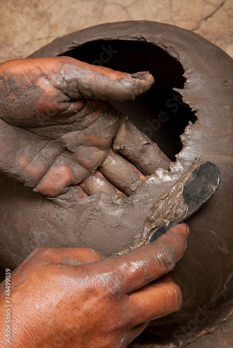 vaso artesanal de barro sendo moldado por artesã