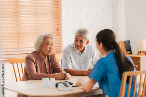 Health insurance service, Young Asian caregiver nurse examine senior man or woman patient at home. Attractive specialist career female support give advise and therapy consult to older elderly mature