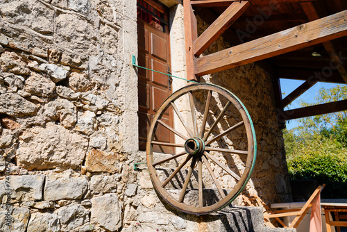 farm typical ancient building with old horse cart wheel in facade in lozere aveyron