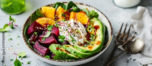 A dish of salad made with avocado, beets, spinach, and eggs is displayed on a table. The combination of fresh ingredients creates a nutritious and flavorful meal.