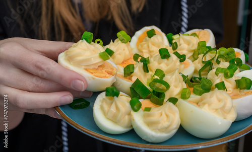 Jeść jajko na twardo udekorowane majonezem, cały talerz z bliska trzymany w dłoni 