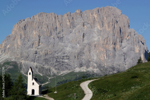 Photo with a view of the Cappella di San Maurizio church against the backdrop of the Sassolungo mountain range in the Dolomites, Val Gardena region, South Tyrol, Italy