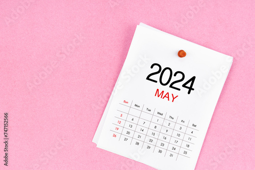 ?ฟั 2024 calendar page and wooden push pin on pink background.