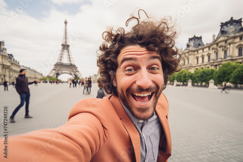 Happy tourist take selfie self-portrait in Paris. Smiling man on vacation looking at the camera. Holidays and travel