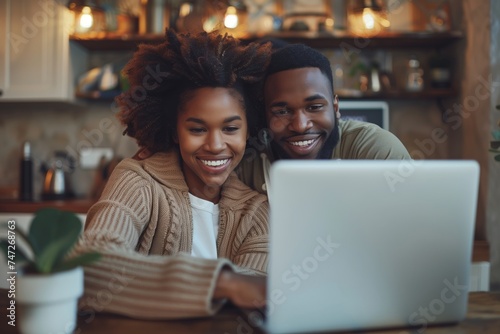 Young cheerful couple using a laptop together at home, possibly shopping online, planning a trip or studying, showcasing shared digital experiences.