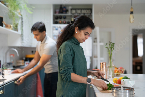 Woman and man preparing food in kitchen