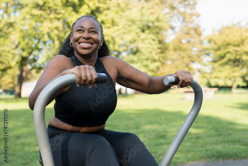 Smiling young woman exercising in outdoor gym