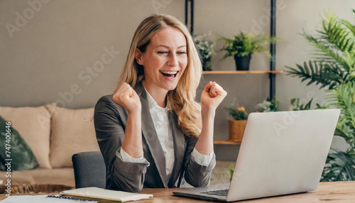 woman working on laptop and celebrating her success; happy businesswoman working from home