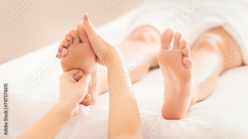 Foot massage. Woman relaxing at spa salon