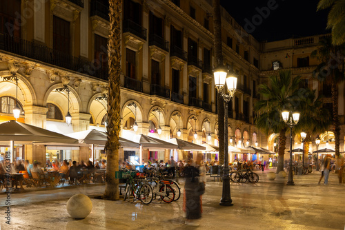 Place of attraction for tourists and citizens of Barcelona is Royal Square. Warm summer evening in light of street-lamp in Gothic quarter