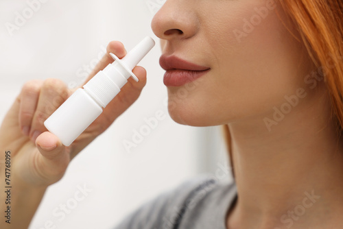 Medical drops. Woman using nasal spray at home, closeup