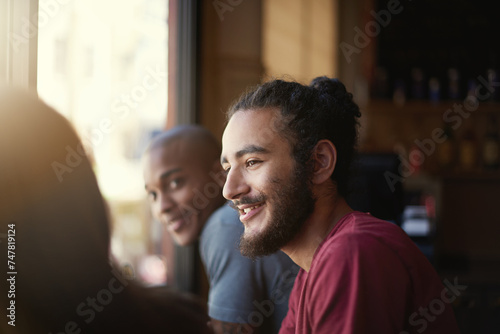 Face, smile and man with friends in coffee shop together for conversation or bonding on weekend. Customer, relax and summer with group of happy young friends in cafe or restaurant for time off