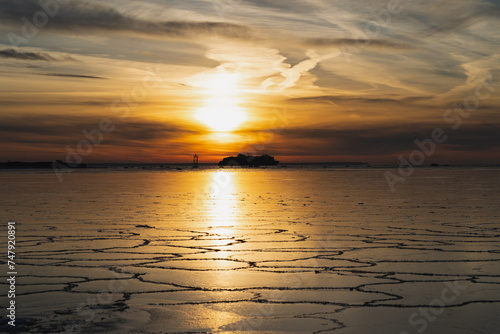 Seascape in winter at sunset. View from the shore of Viimsi, a ferry sailing on the frozen sea.