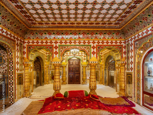 The Shobha Niwas room, richly decorated with gold and glasswork, at the Jaipur City Palace in Rajasthan, India.