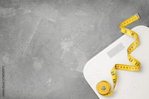 scales and measuring tape on a gray background. diet and weight loss concept