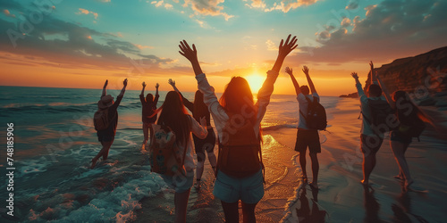 Group of friends celebrating with raised hands on a sunset beach, expressing freedom and joy