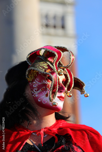 Masked person with decorated clothes and mask with unrecognizable face during the celebration of the Venice Carnival