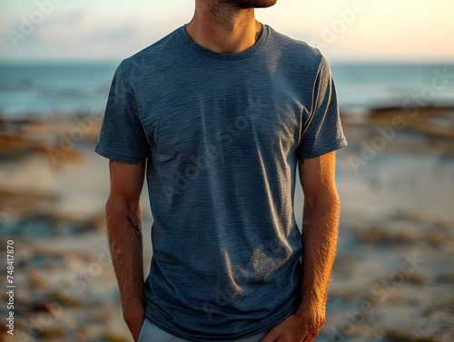 Man in Blue Shirt Looking at the Ocean on a Beach