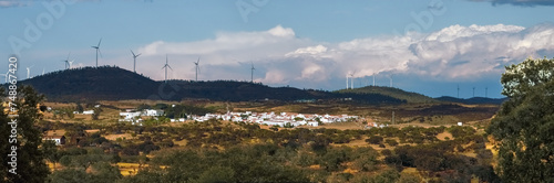 El Granado, un pequeño pueblo de casas encaladas en el suroeste de España. Pueblo situado en un valle rodeado de colinas. Parque eólico El Sardón al fondo sobre el paraje del mismo nombre.