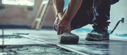 Worker hand placing ceramic floor tiles