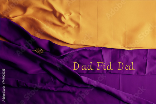 Purple and gold fabric with a gold brooch and the words "Dad Fid Ded" written in gold letters.