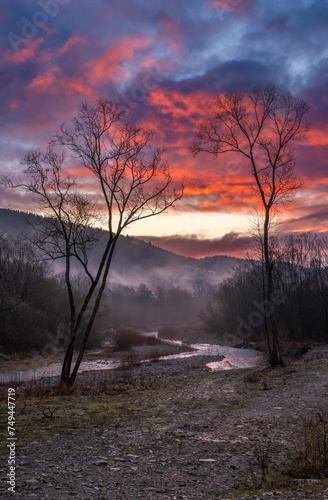 Zjawiskowy, czerwony wschód słońca nad górskim potokiem w Gorcach