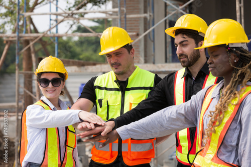 Group of male and female engineer construction working and join hands together at construction site. Foreman construction working at construction site
