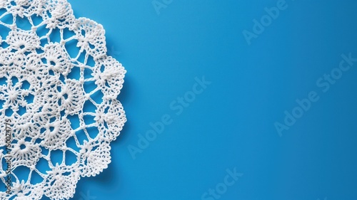 Delicate white lace doily on a bright blue background