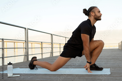 man flexing legs in kneeling hip flexor stretch exercising outdoors