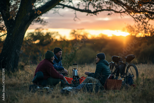 bikers seated around a campfire, studying a map in the fading natural light of dusk